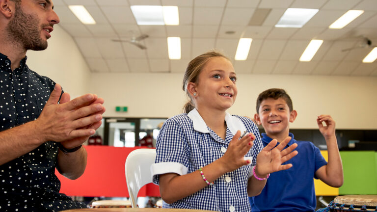 teacher teaching Rhythm and Beat with two primary school students engaged in music arts learning class