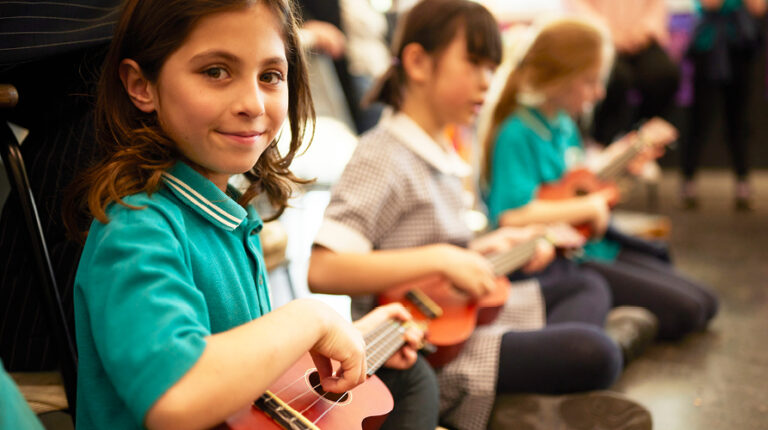 primary school students engaged in music arts learning lesson on ukelele for formative assessment